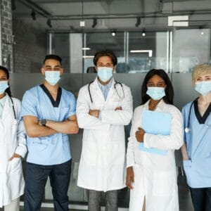 International medical team in face masks having team-building