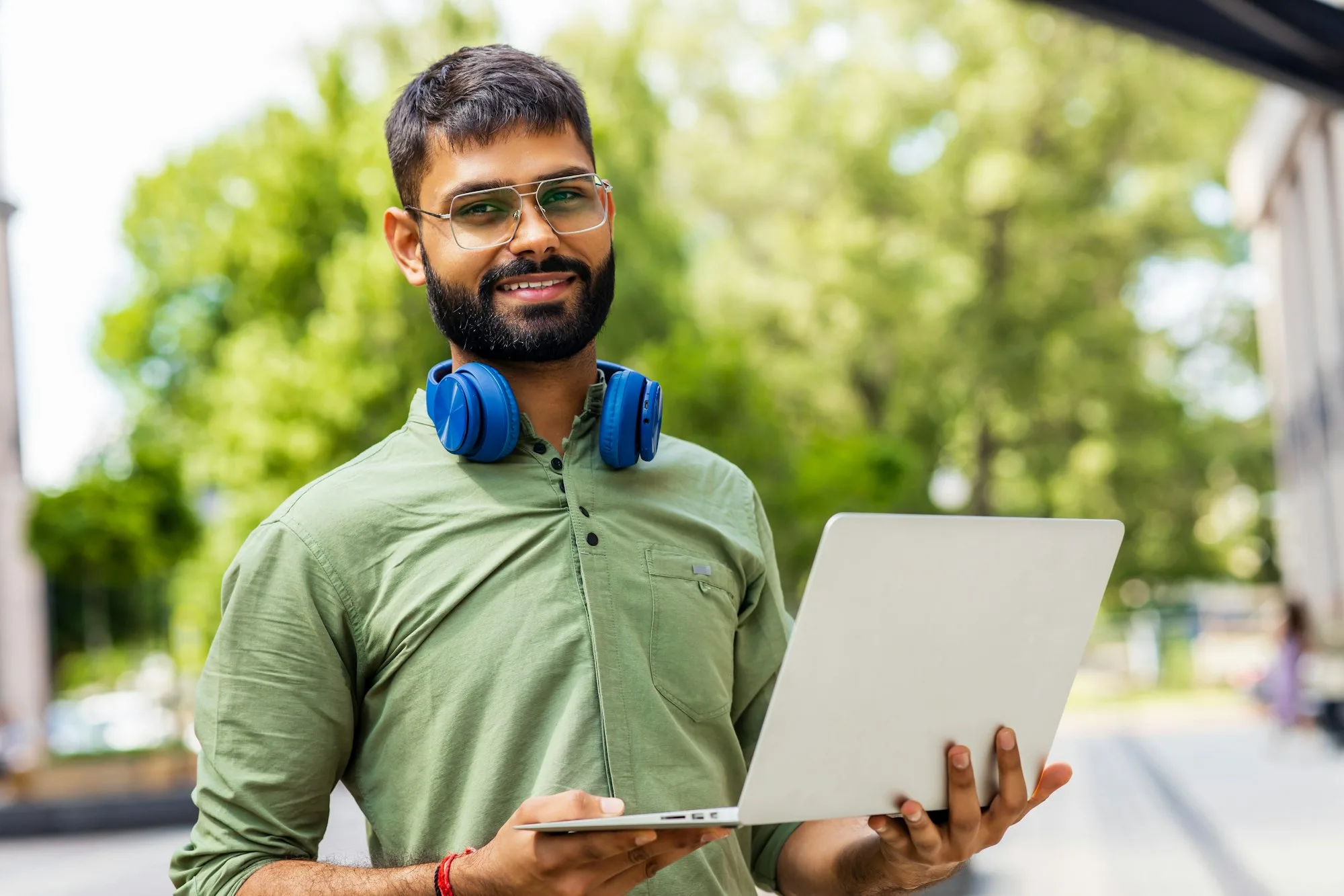 Portrait Indian student programmer using laptop computer in park