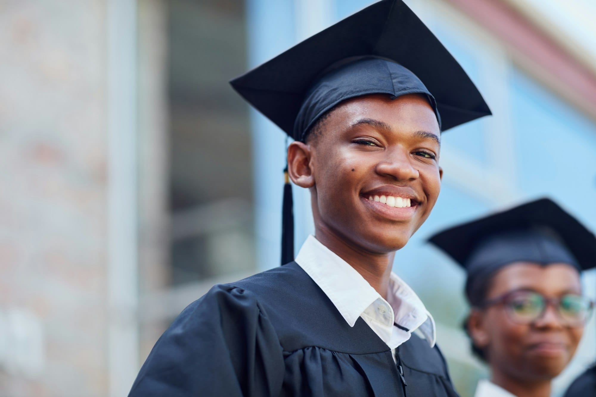 Portrait of a happy male student standing outside on his graduation day