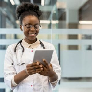 Smiling doctor using a tablet in a modern medical office