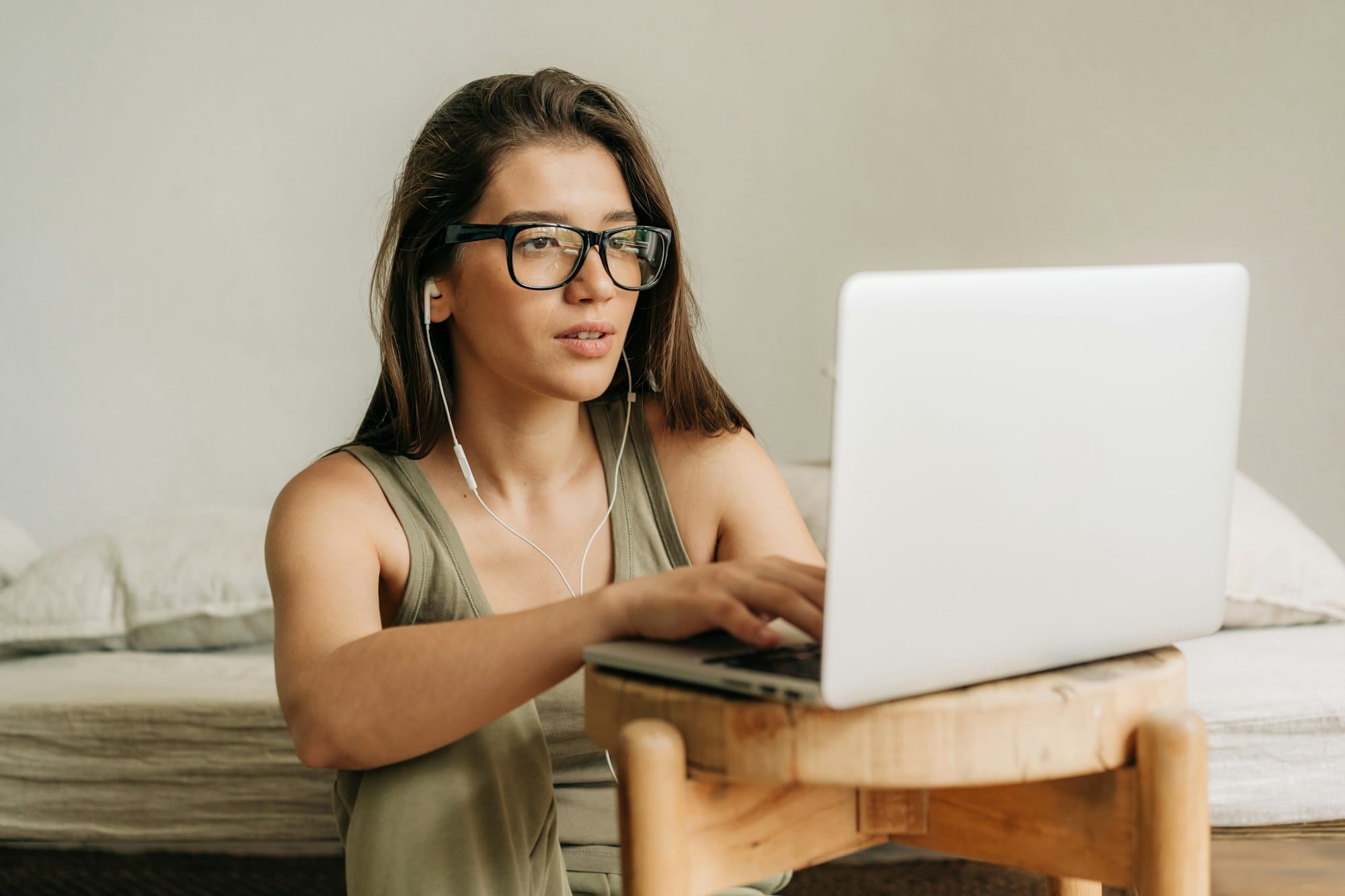 Young female student studying using laptop and headphones.