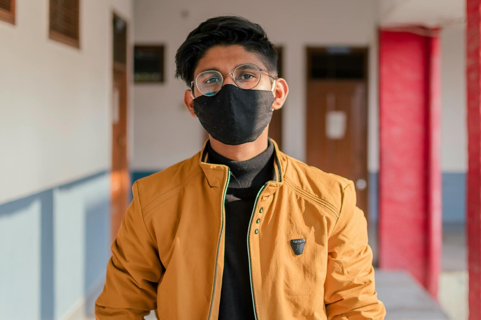 Portrait of a young man wearing eyeglasses and a mask, indoors, in Dehradun, India.